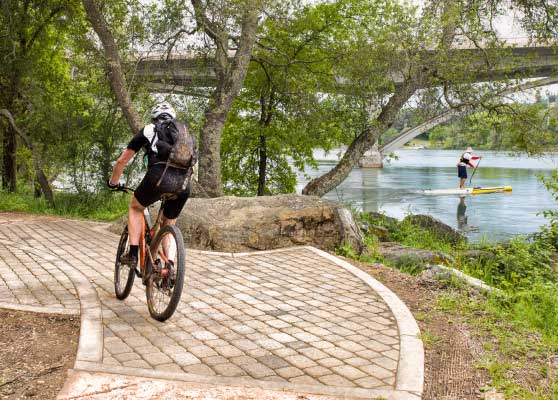 man riding bike on paved trail next to Folsom lake