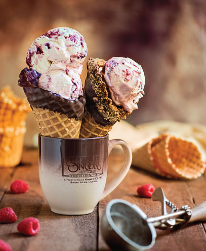 close up photo of two waffle cones filled with ice cream sitting in a snooks mug