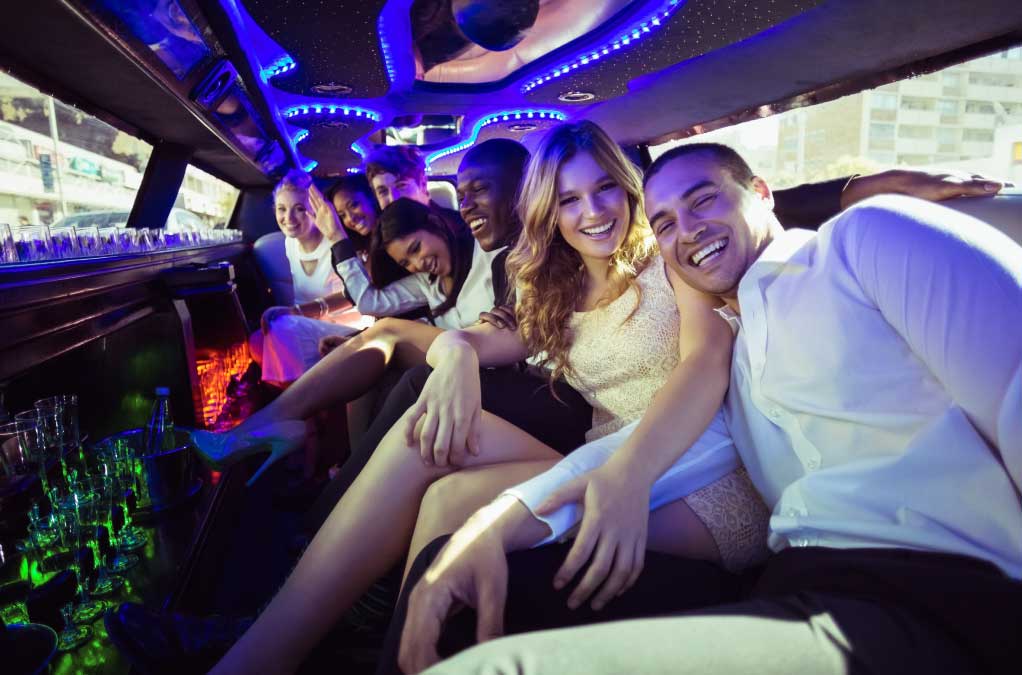 group of friends laughing inside of a limo.