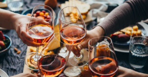 top down view of hands toasting with glasses of wine