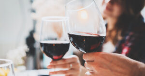 two people toasting with wine glasses