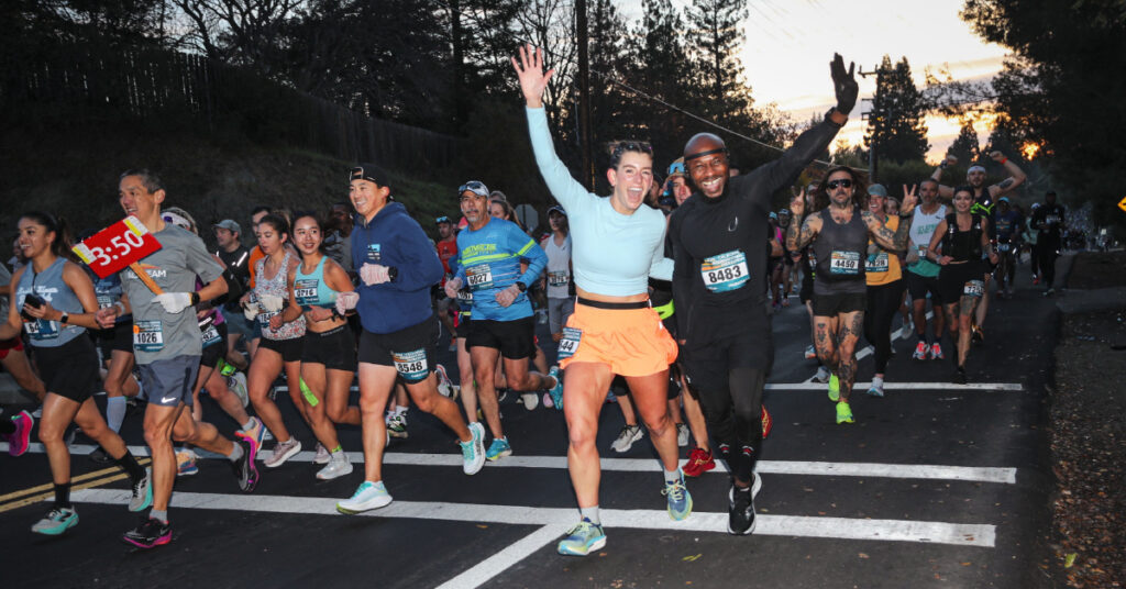 Man and Woman Running across the finish line at the CIM