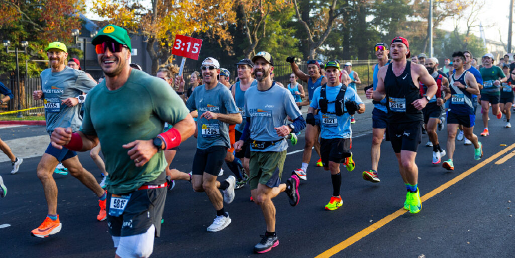 Group of runners at the CIM running and smiling at the camera