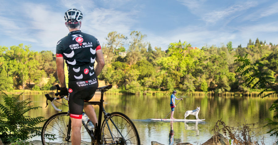 man on a bike looking out at lake natoma