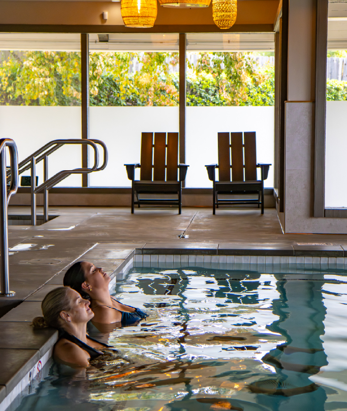 two women enjoying time in a indoor pool