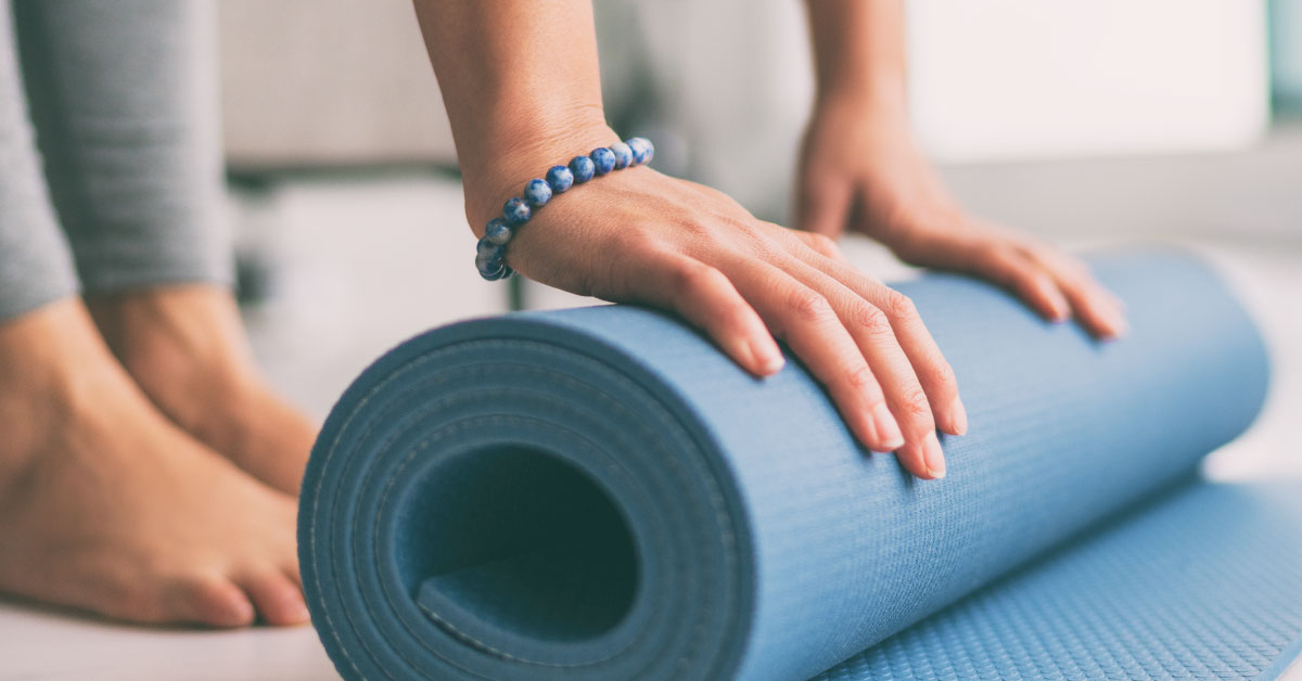woman laying out a yoga mat
