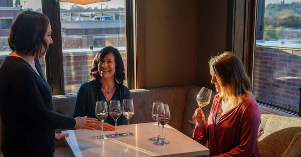 A server serving two women at a winery