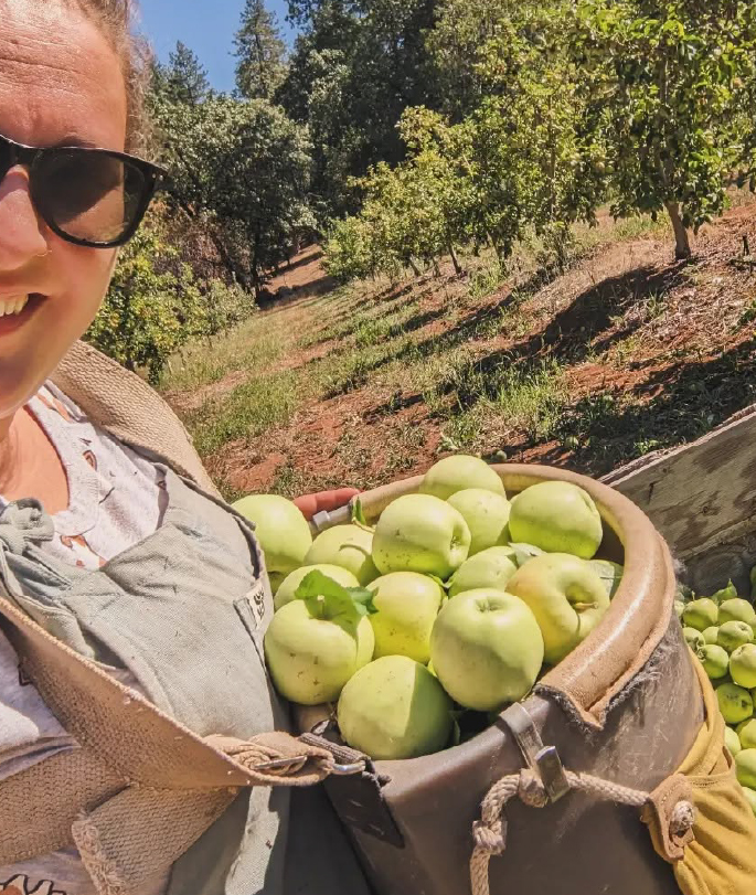 Women Holding backset of apples on farm