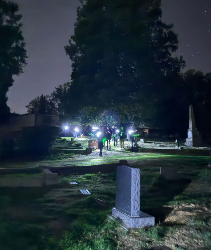 People walking through and moonlight tour through cemetery